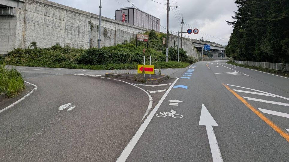 左折を示す矢印看板が立つ道路の分かれ道